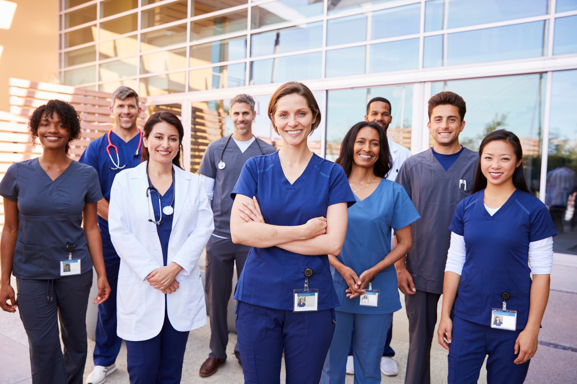 Team of healthcare workers with ID badges outside hospital