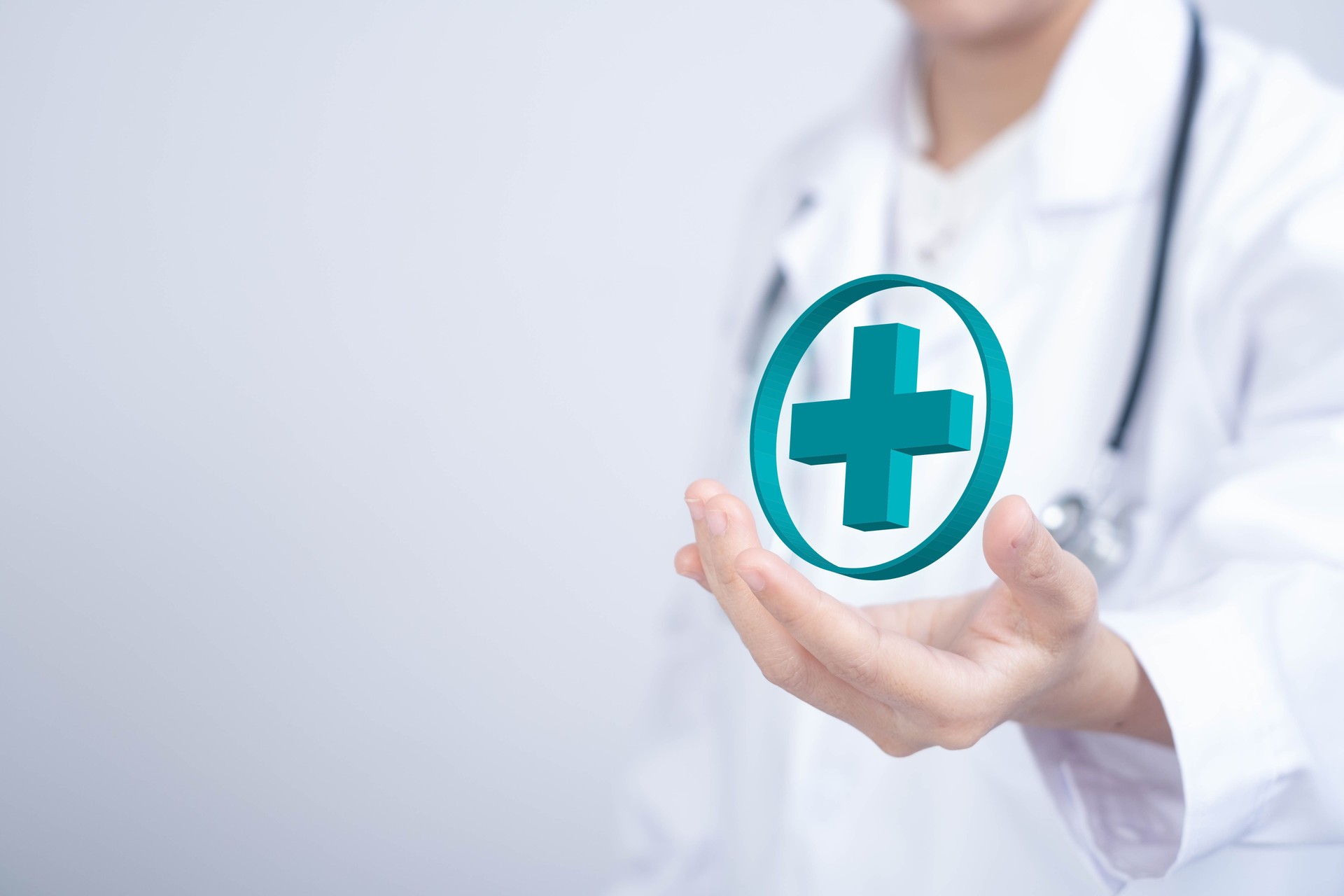 A medical professional holds a 3D health symbol above their hand, symbolizing care, health, and technology in the medical field.